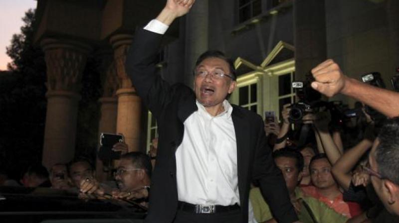 Anwar, 70, smiled and waved to supporters as he walked out of hospital, dressed in a black suit and tie and his hair neatly swept back. (Photo- AP) Anwar, 70, smiled and waved to supporters as he walked out of hospital, dressed in a black suit and tie and his hair neatly swept back. (Photo- AP)
