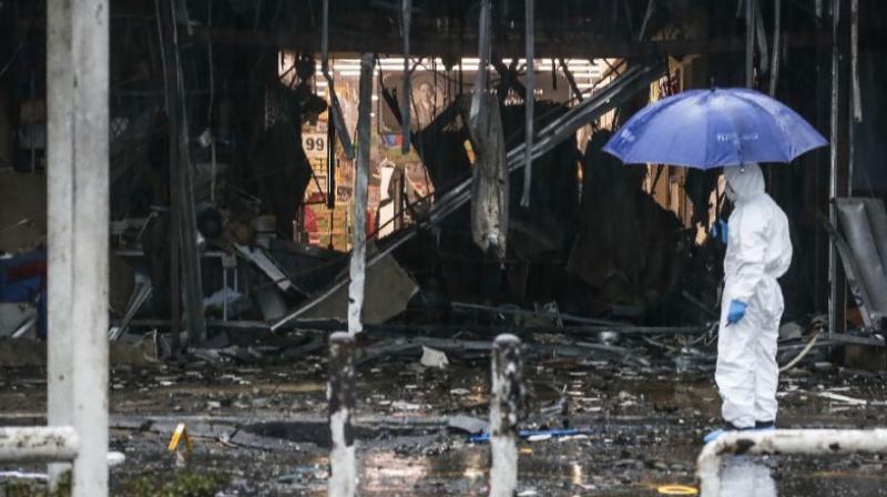 A Thai forensics worker shields himself with an umbrella whilst inspecting the aftermath of a bomb attack in the town centre of Pattani (Photo: AFP) A Thai forensics worker shields himself with an umbrella whilst inspecting the aftermath of a bomb attack in the town centre of Pattani (Photo: AFP)
