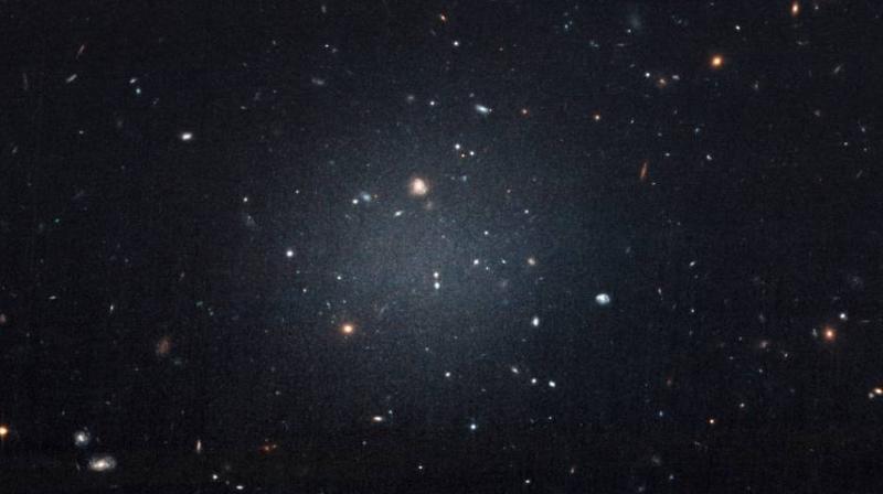 This Nov. 16image made with the Hubble Space Telescope shows the diffuse galaxy NGC 1052-DF2, lighter area in center. Several other galaxies can be seen through it. The unusual galaxy's stars are speeding around with no apparent influence from dark matter, according to a study published on Wednesday in the journal Nature. (Photo: AP) This Nov. 16image made with the Hubble Space Telescope shows the diffuse galaxy NGC 1052-DF2, lighter area in center. Several other galaxies can be seen through it. The unusual galaxy's stars are speeding around with no apparent influence from dark matter, according to a study published on Wednesday in the journal Nature. (Photo: AP)