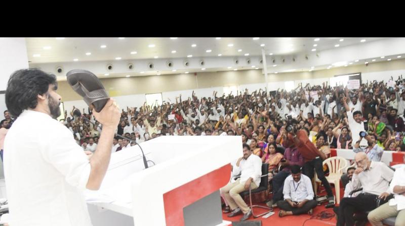 Jana Sena Chief Pawan Kalyan showing the chappal to YCP MLAs at the activists meeting at Mangalagiri party office in Guntur District on Tuesday.  By Arrangement