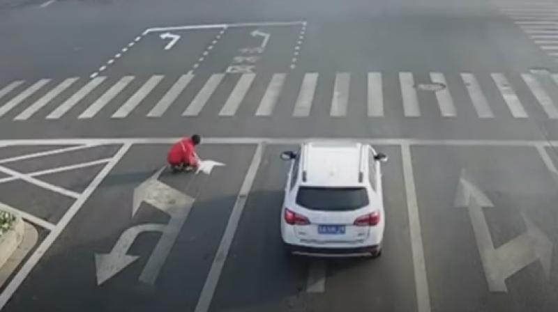 Surveillance footage shows him painting his own arrows at a junction in the eastern city of Lianyungang. (Photo: Youtube/CGTN) Surveillance footage shows him painting his own arrows at a junction in the eastern city of Lianyungang. (Photo: Youtube/CGTN)