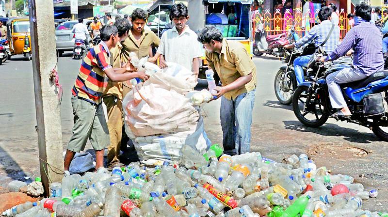 Civic staff remove plastic waste including bottles from an underground drainage line at Devi Chowk in Rajahmundry on Friday. (DC) Civic staff remove plastic waste including bottles from an underground drainage line at Devi Chowk in Rajahmundry on Friday. (DC)