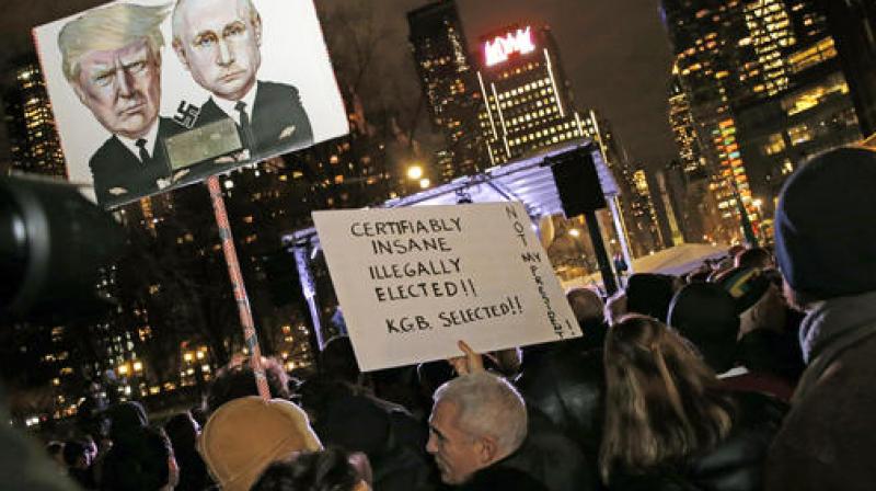 People hold signs during an anti-Trump rally and protest hosted by filmmaker Michael Moore in front of the Trump International Hotel in New York. (Photo: AP) People hold signs during an anti-Trump rally and protest hosted by filmmaker Michael Moore in front of the Trump International Hotel in New York. (Photo: AP)