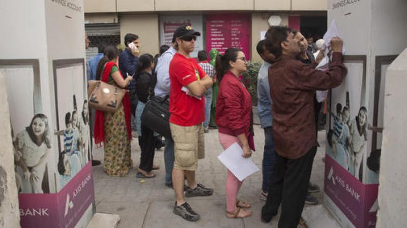 TForeign tourist stand in a queue to exchange discontinued currency notes outside a bank in New Delhi. (Photo: PTI) TForeign tourist stand in a queue to exchange discontinued currency notes outside a bank in New Delhi. (Photo: PTI)