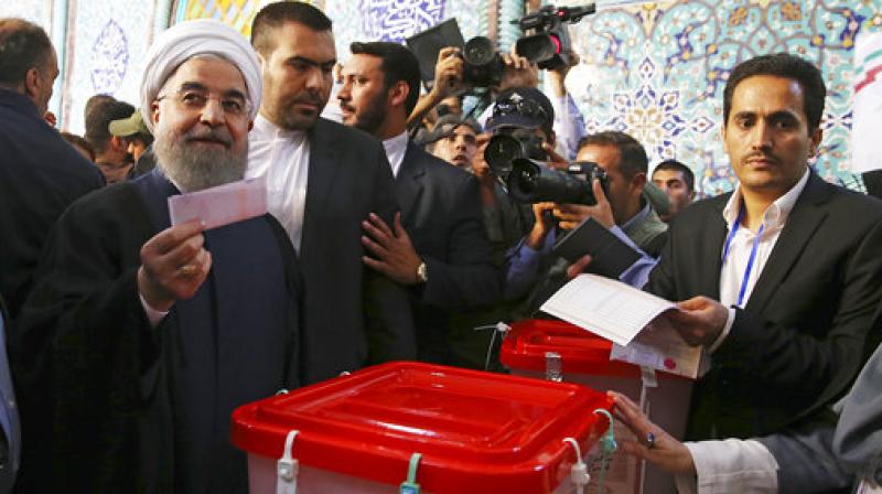 President Hassan Rouhani holds his ballot while voting for the presidential and municipal councils election at a polling station in Tehran, Iran. (Photo: AP) President Hassan Rouhani holds his ballot while voting for the presidential and municipal councils election at a polling station in Tehran, Iran. (Photo: AP)