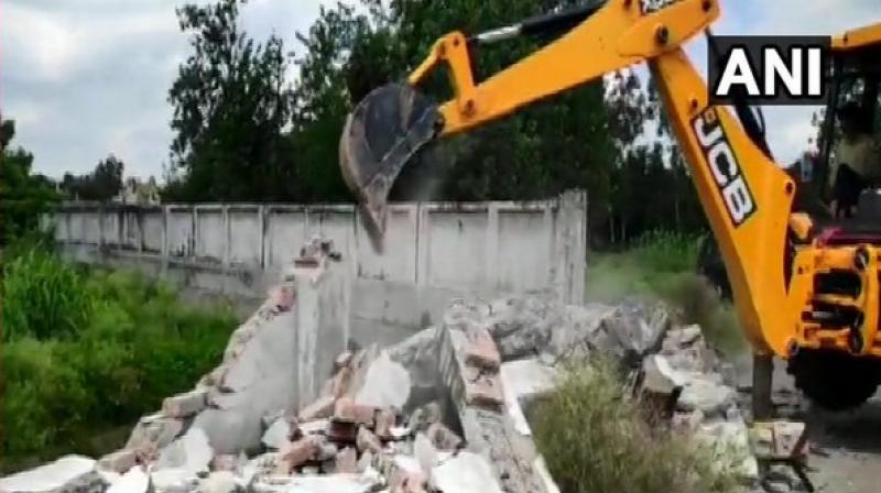 'The irrigation department along with the district administration demolished the wall today which was erected illegally,' official said. (Photo: ANI) 'The irrigation department along with the district administration demolished the wall today which was erected illegally,' official said. (Photo: ANI)
