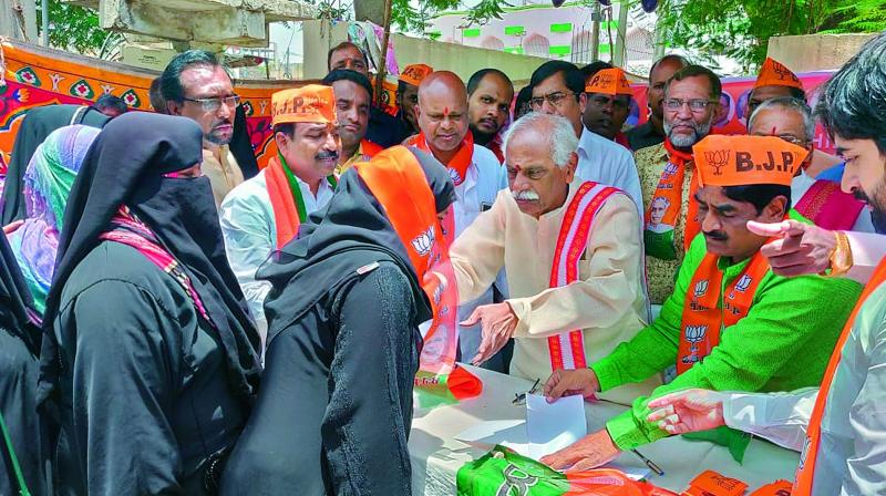 Senior BJP leader Bandaru Dattatreya hands over party membership slips to women on Wednesday. (Photo: DC) Senior BJP leader Bandaru Dattatreya hands over party membership slips to women on Wednesday. (Photo: DC)