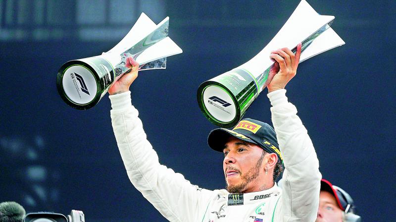 Mercedes driver Lewis Hamilton of Britain raises trophies after winning the Brazilian Formula One Grand Prix at the Interlagos race track in Sao Paulo, Brazil, on Sunday. (Photo: AP) Mercedes driver Lewis Hamilton of Britain raises trophies after winning the Brazilian Formula One Grand Prix at the Interlagos race track in Sao Paulo, Brazil, on Sunday. (Photo: AP)