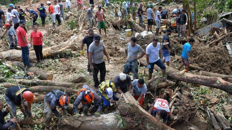 Locals join the search for victims of a landslide triggered by torrential rains during the week-end in Guaruja, Brazil on March 4, 2020.