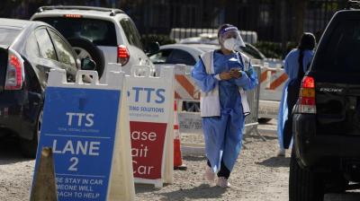 Workers wear protective equipment at a COVID-19 testing site in the Boyle Heights section of Los Angeles.  (AP/Marcio Jose Sanchez)