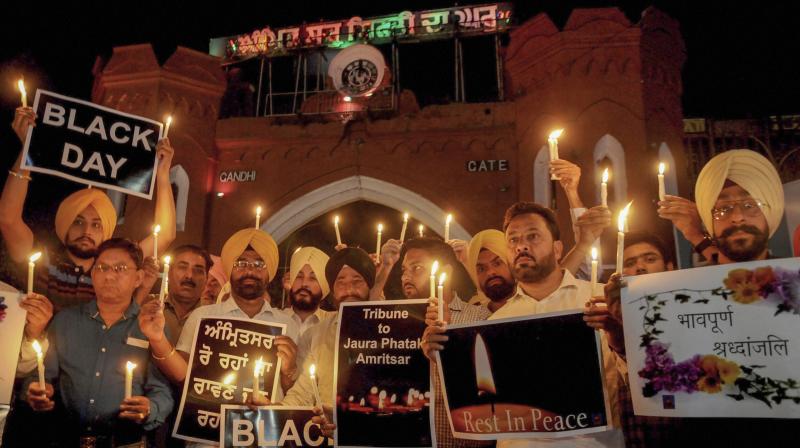Members of National Human Rights and crime control organisation participate in a candlelight vigil to pay tribute to victims of Amritsar train accident. (Photo: PTI) Members of National Human Rights and crime control organisation participate in a candlelight vigil to pay tribute to victims of Amritsar train accident. (Photo: PTI)