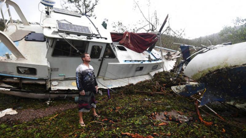 Bradley Mitchell inspects the damage to his uncle's boat after it smashed against the bank at Shute Harbour, Airlie Beach, Australia (Photo: AP) Bradley Mitchell inspects the damage to his uncle's boat after it smashed against the bank at Shute Harbour, Airlie Beach, Australia (Photo: AP)
