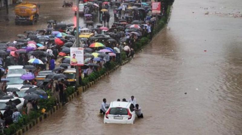 Vehicles stuck at a flooded street after heavy rains in Thane, Mumbai on Tuesday. (Photo: PTI) Vehicles stuck at a flooded street after heavy rains in Thane, Mumbai on Tuesday. (Photo: PTI)