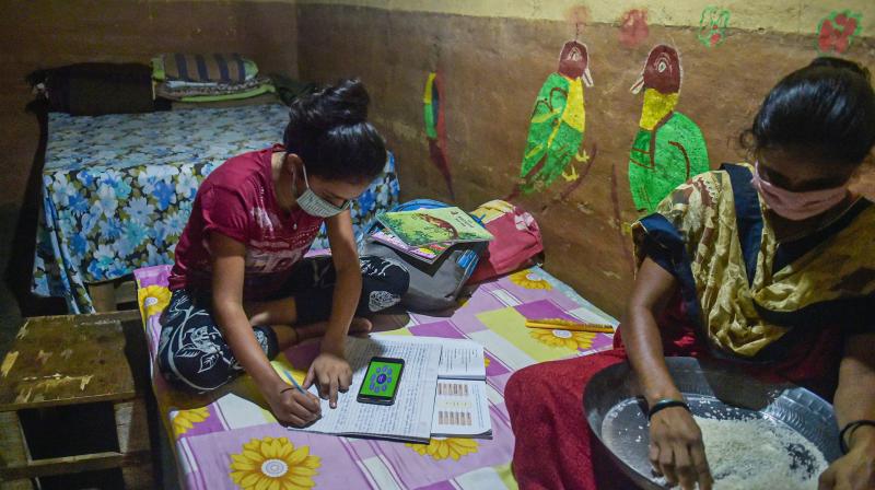 Roshni Nere, a class 10th student of BMC school, studies at her house as her mother works, at Aarey Colony in Mumbai. PTI Photo Roshni Nere, a class 10th student of BMC school, studies at her house as her mother works, at Aarey Colony in Mumbai. PTI Photo