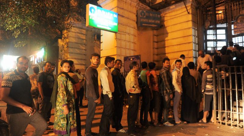 People lined up outside an ATM to withdraw 100 rupees notes in New Delhi on Tuesday after Prime Minister Narendra Modi on Tuesday announced demonetization of Rs 500 and 1000 currency notes with effect from midnight. (Photo: PTI) People lined up outside an ATM to withdraw 100 rupees notes in New Delhi on Tuesday after Prime Minister Narendra Modi on Tuesday announced demonetization of Rs 500 and 1000 currency notes with effect from midnight. (Photo: PTI)