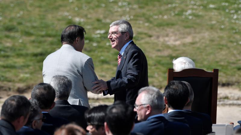 International Olympic Committee (IOC) president Thomas Bach speaks with Paralympic Games Vice President Toshiaki Endo (back) during the Olympic flame lighting ceremony in ancient Olympia, Greece, on Thursday. AFP Photo International Olympic Committee (IOC) president Thomas Bach speaks with Paralympic Games Vice President Toshiaki Endo (back) during the Olympic flame lighting ceremony in ancient Olympia, Greece, on Thursday. AFP Photo