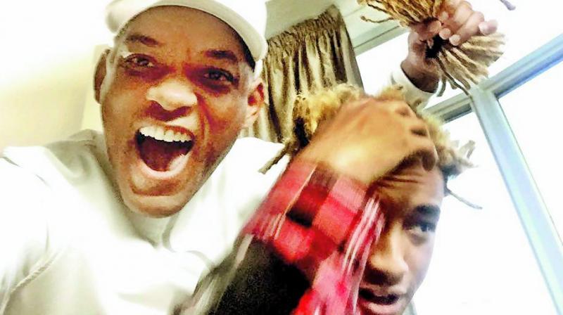 Teamwork: Will Smith poses with Jaden’s dreads that he chopped off Teamwork: Will Smith poses with Jaden’s dreads that he chopped off