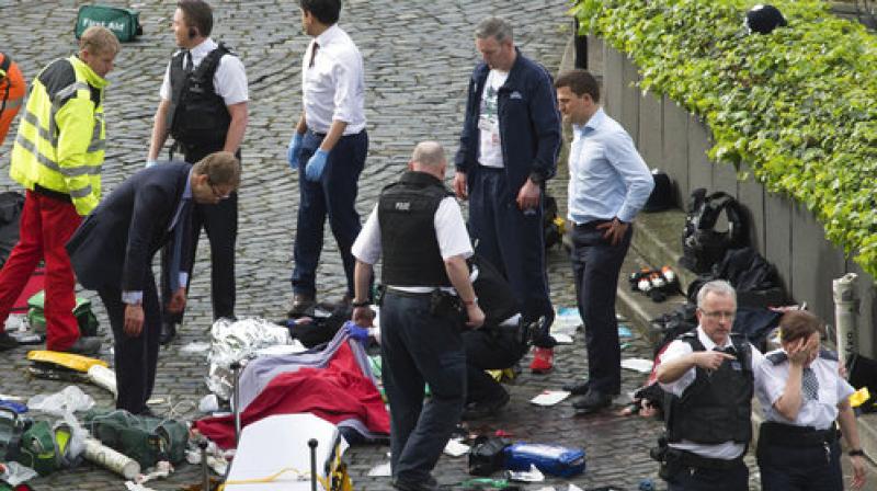 Conservative MP Tobias Ellwood, left, stands amongst the emergency services at the scene outside the Palace of Westminster, London. (Photo: AP) Conservative MP Tobias Ellwood, left, stands amongst the emergency services at the scene outside the Palace of Westminster, London. (Photo: AP)