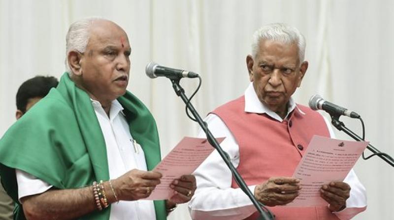 Karnataka Governor Vajubhai Vala administers oath to Bharatiya Janata Party (BJP) leader B. S. Yeddyurappa as Chief Minister of the state at a ceremony in Bengaluru on Thursday. (Photo: PTI) Karnataka Governor Vajubhai Vala administers oath to Bharatiya Janata Party (BJP) leader B. S. Yeddyurappa as Chief Minister of the state at a ceremony in Bengaluru on Thursday. (Photo: PTI)