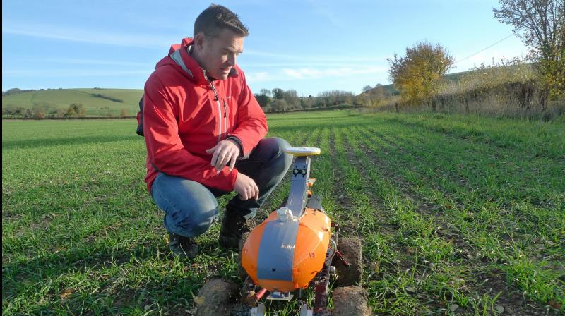 Joe Allnutt, lead roboticist at British startup company the Small Robot Company, inspects a farming robot named Tom as part of a trial in East Meon, southern England, Friday Nov. 30, 2018. The “agri-tech” startup company is developing lightweight autonomous machines that can carry out precision “seeding, feeding and weeding” in the hope of transforming food production. (AP Photo / Kelvin Chan) Joe Allnutt, lead roboticist at British startup company the Small Robot Company, inspects a farming robot named Tom as part of a trial in East Meon, southern England, Friday Nov. 30, 2018. The “agri-tech” startup company is developing lightweight autonomous machines that can carry out precision “seeding, feeding and weeding” in the hope of transforming food production. (AP Photo / Kelvin Chan)