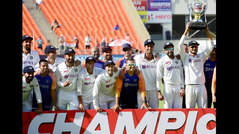 Indian cricket team players pose with the trophy after defeating England in the third days play of the 4th Test at Narendra Modi Stadium in Ahmedabad on Saturday. -- PTI