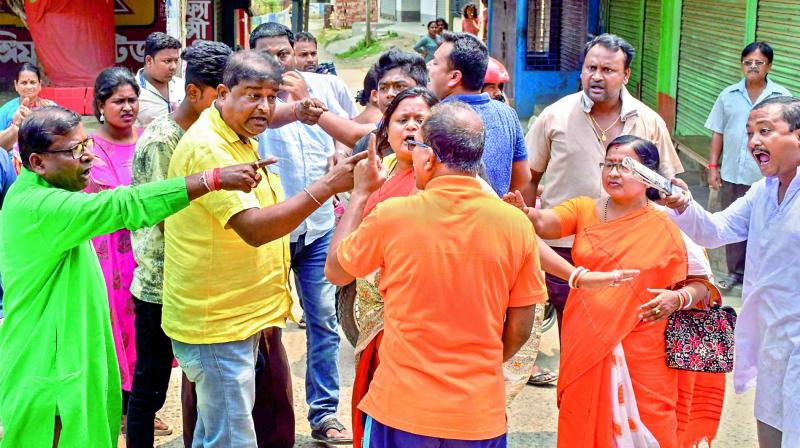 TMC and BJP workers quarrel outside a polling station, during the third phase of Lok Sabha elections, in Malda district of West Bengal on Tuesday. (Photo: AP) TMC and BJP workers quarrel outside a polling station, during the third phase of Lok Sabha elections, in Malda district of West Bengal on Tuesday. (Photo: AP)