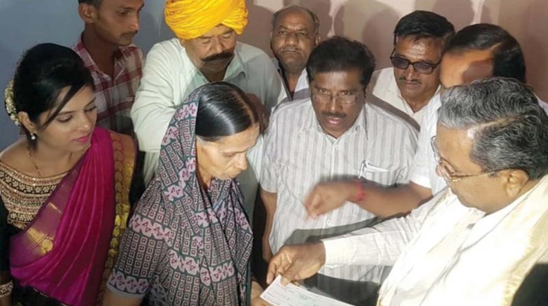 Former CM Siddaramaiah gives a compensation cheque to the kin of the farmer who had committed suicide, at Hireboodihala in Badami, Bagalkote district. Former CM Siddaramaiah gives a compensation cheque to the kin of the farmer who had committed suicide, at Hireboodihala in Badami, Bagalkote district.