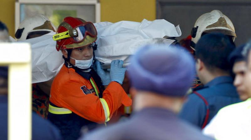 The body of a victim is carried out by rescue personnel from an Islamic religious school after a fire on the outskirts of Kuala Lumpur (Photo: AP) The body of a victim is carried out by rescue personnel from an Islamic religious school after a fire on the outskirts of Kuala Lumpur (Photo: AP)