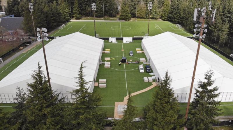 two massive temporary buildings meant for use as a field hospital for coronavirus patients stand together on a soccer field in the Seattle suburb (AP) two massive temporary buildings meant for use as a field hospital for coronavirus patients stand together on a soccer field in the Seattle suburb (AP)