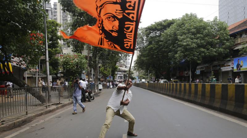 A Maratha community member waves a flag with a portrait of Shivaji, the founder of Maratha dynasty, during a protest in Mumbai. Protests are being held in different parts of Maharashtra state by the community to demand reservation in government jobs and education. (Photo: AP) A Maratha community member waves a flag with a portrait of Shivaji, the founder of Maratha dynasty, during a protest in Mumbai. Protests are being held in different parts of Maharashtra state by the community to demand reservation in government jobs and education. (Photo: AP)