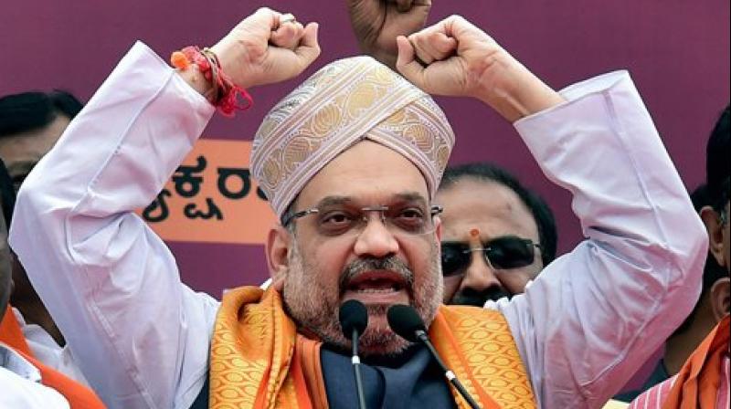 BJP president Amit Shah wears a Mysore Peta, a traditional headgear, upon his arrival on a three-day visit to Karnataka as part of his 110-day nationwide tour, in Bengaluru on Saturday. (Photo: PTI) BJP president Amit Shah wears a Mysore Peta, a traditional headgear, upon his arrival on a three-day visit to Karnataka as part of his 110-day nationwide tour, in Bengaluru on Saturday. (Photo: PTI)