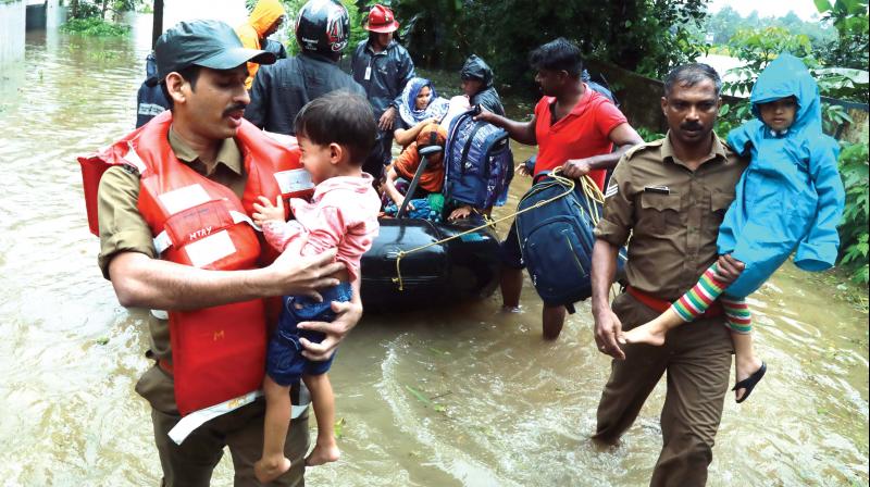 Fire and Rescue personnel evacuate residents of Muppathadam near Eloor in Kochi on Thursday. (Image: Arun Chandra Bose) Fire and Rescue personnel evacuate residents of Muppathadam near Eloor in Kochi on Thursday. (Image: Arun Chandra Bose)
