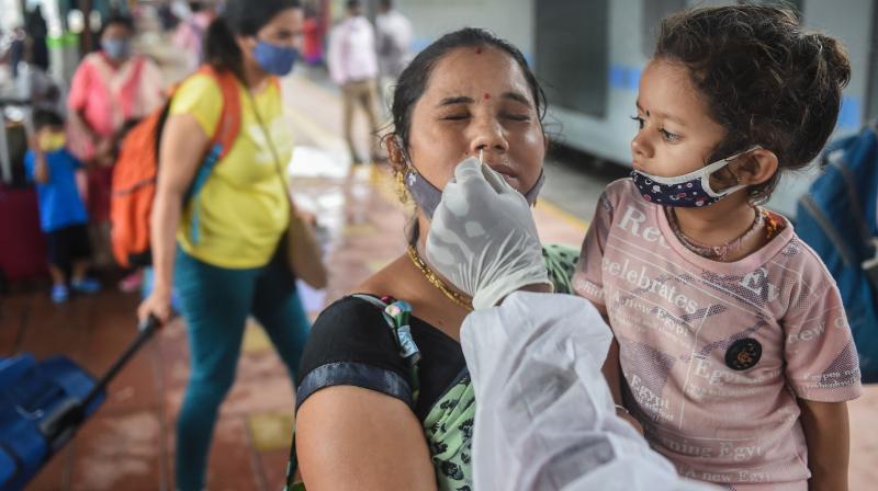 A BMC health worker collects swab sample of a passenger for COVID-19 test, at a station in Mumbai, Sunday, July 11, 2021. (PTI/Shashank Parade) A BMC health worker collects swab sample of a passenger for COVID-19 test, at a station in Mumbai, Sunday, July 11, 2021. (PTI/Shashank Parade)