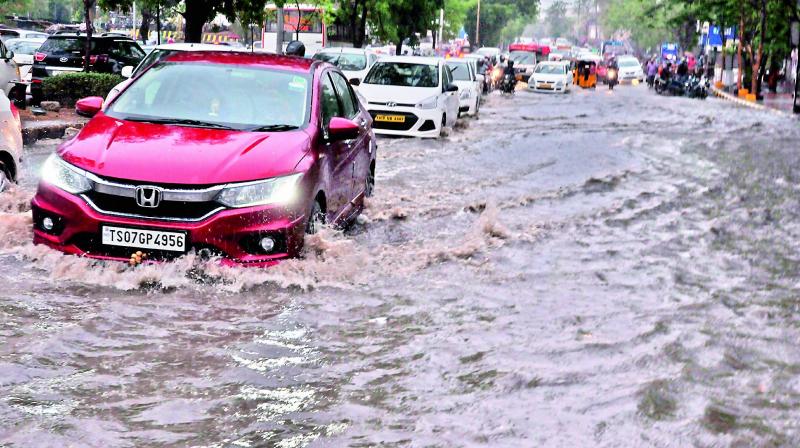 A car swims across the rain water logged road in Gachibowli on Friday. A car swims across the rain water logged road in Gachibowli on Friday.