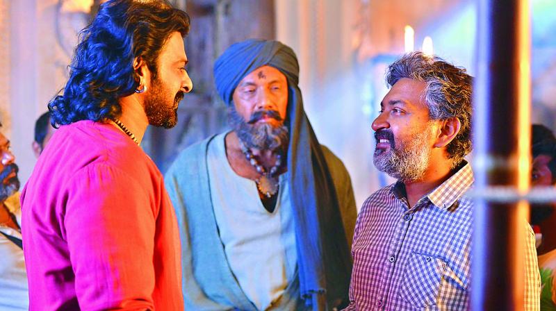 Actors Prabhas and Sathyaraj along with director S.S. Rajamouli, in discussion during the shoot of Baahubali Actors Prabhas and Sathyaraj along with director S.S. Rajamouli, in discussion during the shoot of Baahubali