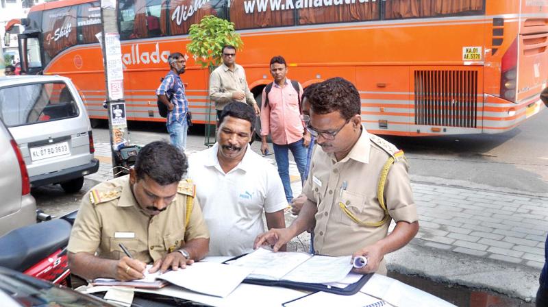 Motor Vehicle Department officials inspect inter-state private bus services in Kochi on Thursday morning. (SUNOJ NINAN MATHEW) Motor Vehicle Department officials inspect inter-state private bus services in Kochi on Thursday morning. (SUNOJ NINAN MATHEW)
