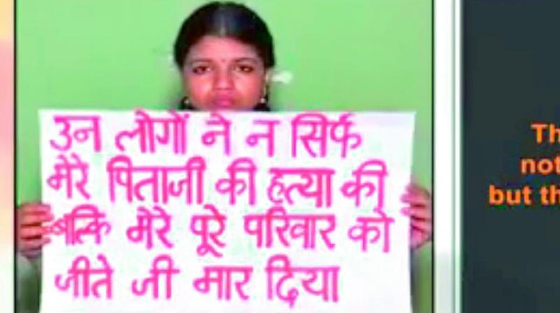 Vismaya holds a placard that reads ‘they have murdered not just my father, but my family too’ in Hindi. Vismaya holds a placard that reads ‘they have murdered not just my father, but my family too’ in Hindi.