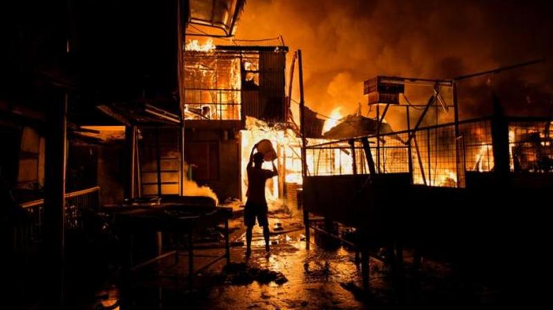 A resident pours water on a fire in Delpan, Tondo, Manila. (Photo: AFP) A resident pours water on a fire in Delpan, Tondo, Manila. (Photo: AFP)