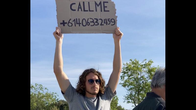 Stefanis Tsitsipas holds up the cardboard on which he wrote Kyrgios number. Twitter Photo