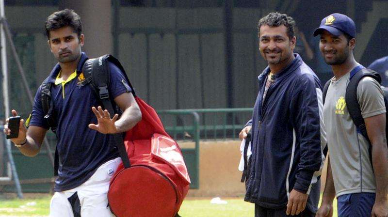 Former Karnataka coach J Arun Kumar (C) with captain Vinay Kumar and wicket-keeper Gautam CM during a practice session at Chinnaswamy stadium in Bengaluru. DC Photo: R. Samuel