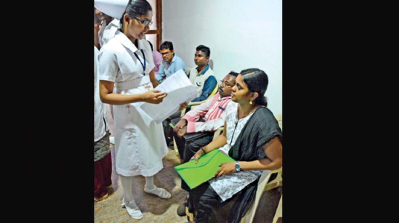 A nurse checks the medical certificate of a differently abled student during counselling. A nurse checks the medical certificate of a differently abled student during counselling.
