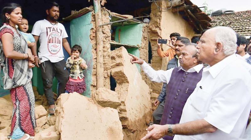 Chief Minister B.S. Yediyurappa speaks to family members whose house was damaged in rain a few days ago in Shivamogga on Tuesday (Photo:PTI) Chief Minister B.S. Yediyurappa speaks to family members whose house was damaged in rain a few days ago in Shivamogga on Tuesday (Photo:PTI)