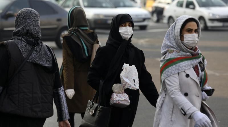 Pedestrians wearing face masks cross a square in western Tehran, Iran, on Saturday. AP Photo