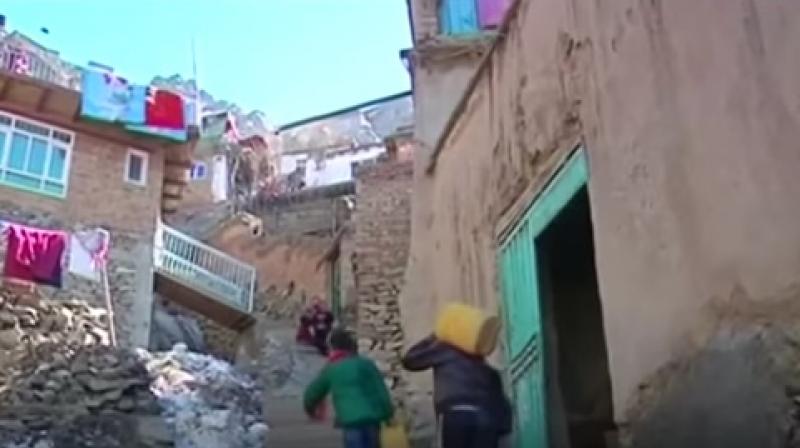 At the base of the hills, children cluster around hand-operated pumps, filling buckets and cans before climbing back up to their homes. (Photo: youtube grab) At the base of the hills, children cluster around hand-operated pumps, filling buckets and cans before climbing back up to their homes. (Photo: youtube grab)