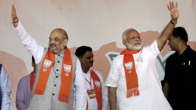BJP chief Amit Shah (L) termed the upcoming Gujarat Assembly polls a 'battle of pride' for the ruling party and exhorted the workers to ensure an improved tally of 150 seats over the 129 it won in 2002 under the then chief minister Narendra Modi (R). (Photo: PTI) BJP chief Amit Shah (L) termed the upcoming Gujarat Assembly polls a 'battle of pride' for the ruling party and exhorted the workers to ensure an improved tally of 150 seats over the 129 it won in 2002 under the then chief minister Narendra Modi (R). (Photo: PTI)