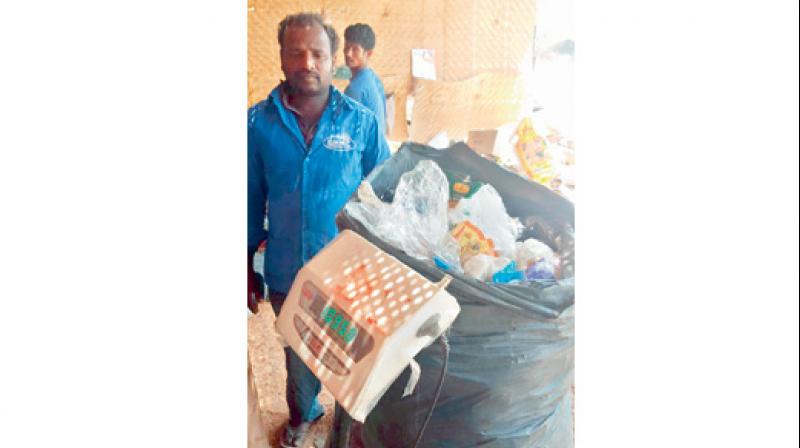Workers handle dry waste at Rajendranagar before it is sold to ITC. Workers handle dry waste at Rajendranagar before it is sold to ITC.