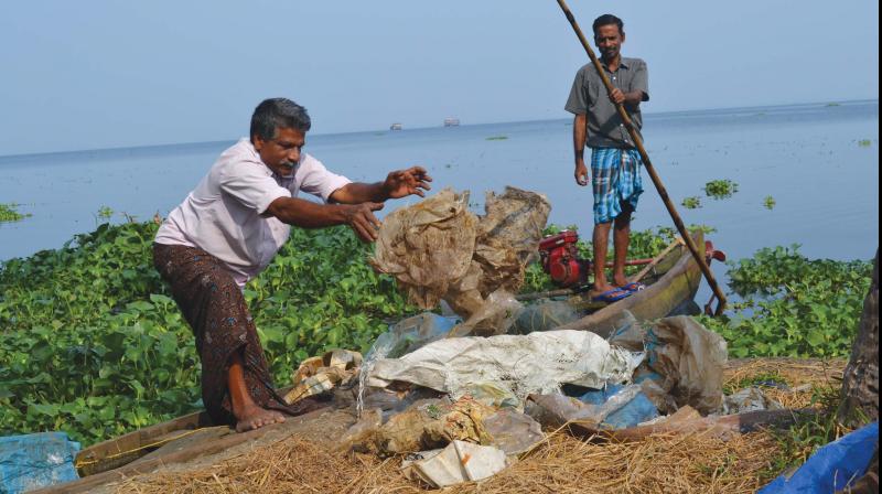 Fishermen collect plastic waste from lake — DC File Fishermen collect plastic waste from lake — DC File