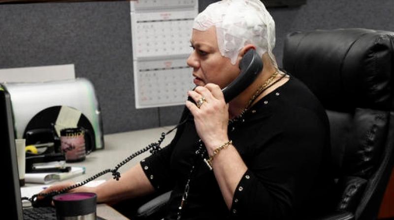 In this March 29, 2017 photo, Joyce Endresen wears an Optune therapy device for brain cancer, as she speaks on a phone at work in Aurora, Ill. She was diagnosed in December 2014 with Glioblastoma. (Photo: AP) In this March 29, 2017 photo, Joyce Endresen wears an Optune therapy device for brain cancer, as she speaks on a phone at work in Aurora, Ill. She was diagnosed in December 2014 with Glioblastoma. (Photo: AP)