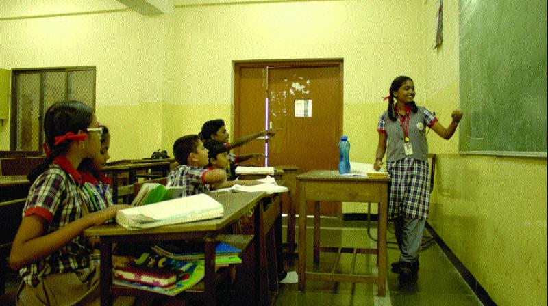 A schoolgirl teaches children from lower classes at a school in Bengaluru. A schoolgirl teaches children from lower classes at a school in Bengaluru.