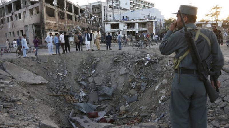 security forces stand next to a crater created by a massive explosion, that killed over 150 according to the Afghan president, in front of the German Embassy in Kabul, Afghanistan. (Photo: AP) security forces stand next to a crater created by a massive explosion, that killed over 150 according to the Afghan president, in front of the German Embassy in Kabul, Afghanistan. (Photo: AP)